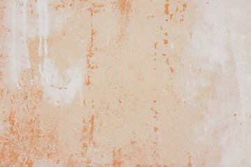 Textured plaster wall surface with peeling paint in various shades of orange and white color. Aged, weathered background. Wallpaper, backdrop, design element