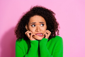 Photo of worried nervous cute woman wear green stylish clothes bite fingernails look empty space isolated on pink color background