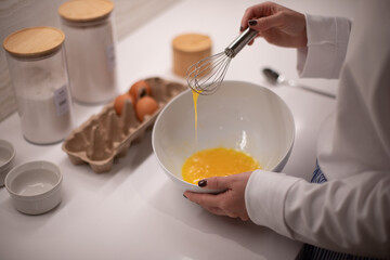 Woman at home in her kitchen cooking, woman hands, culinary blog, step-by-step recipe for cooking a dish, breakfast , recipe, plate and whisk for preparing breakfast