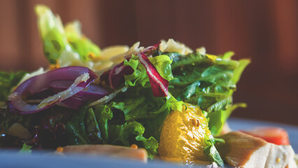 Tasty fresh salad with vegetables on white plate, horizontal image. Close up.