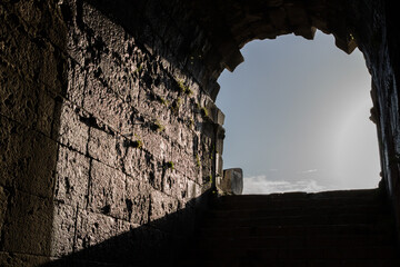 The ancient exit of a tunnel, framed by weathered stone walls. This evocative image transports the...