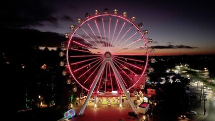 Illuminated Ferris Wheel At Canela In Rio Grande Do Sul Brazil. Colorful Ferris Wheel. Illuminated City. Sunset Landscape. Illuminated Ferris Wheel At Canela In Rio Grande Do Sul Brazil. 