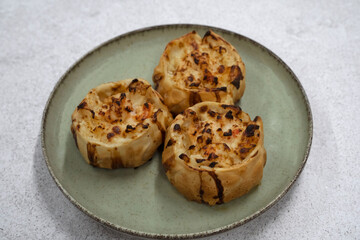 Gourmet seafood. Closeup view of open shrimps empanadas with gratin cheese in a dish	