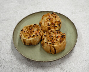 Gourmet seafood. Closeup view of open shrimps empanadas with gratin cheese in a dish	
