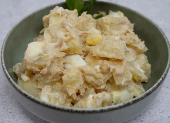 Potato salad. Closeup view of a salad made with tuna, sliced boiled potatoes, a hard boiled chopped egg and mayonnaise in a bowl