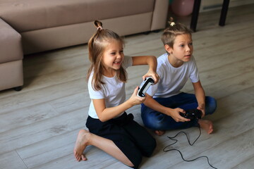 A lively scene of a boy and girl enthusiastically playing video games together at home. they...