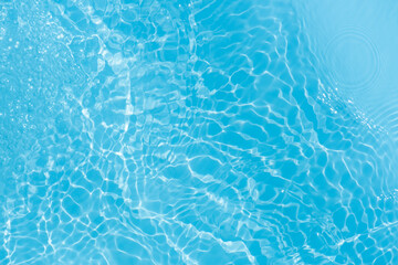 Blue water with ripples on the surface. Defocus blurred transparent blue colored clear calm water surface texture with splashes and bubbles. Water waves with shining pattern texture background.