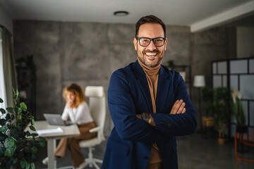 Fototapeta premium Portrait of adult man businessman stand with arm crossed in the office