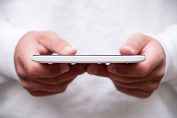 Close up view of young  man holding a tablet outdoors