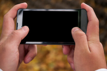 Close up view of male hands typing text message outdoors