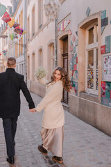 a joyful couple walking through a charming European city in winter. Wedding, love, street style