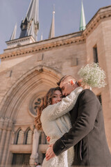 a joyful couple walking through a charming European city in winter. Wedding, love, street style
