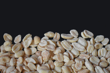 Salted roasted peanuts as background with black insert on the side, top view. Peanut background