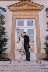 A happy man holding his wife in his arms after their wedding in Europe