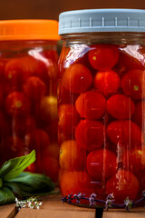 Fermentation of cherry tomatoes and cabbage on a wood garden cart with basil leaves and straw hat