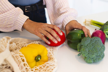 Hands arranging fresh vegetables on kitchen counter, preparing healthy meal, at home