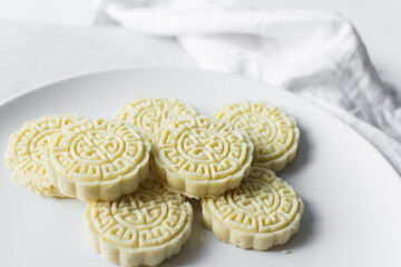 Overhead view of tuwon madara on a white plate, nigerian alawar madara milk candy, top view of milk fudge on a white ceramic plate