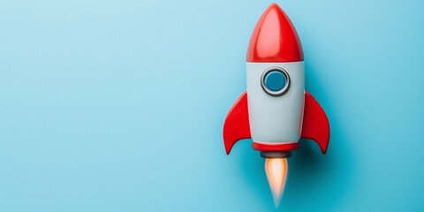 Plastic rocket toy on blue background. Entrepreneurship concept