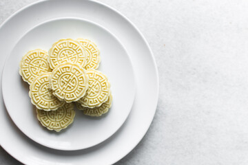 Overhead view of tuwon madara on a white plate, nigerian alawar madara milk candy, top view of milk fudge on a white ceramic plate