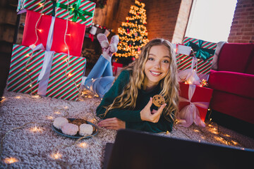 Full body photo of teen girl lying floor netbook snacks wear green christmas clothes cozy x-mas...