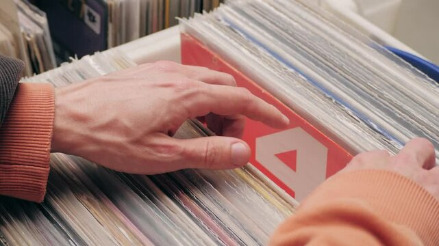 People browsing vinyl records in a music store, surrounded by retro albums in physical format