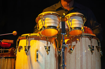playing drums on stage close, concert lights, african drummer