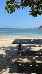 Vista panorámica de una playa rodeada de majestuosas montañas, donde el mar cristalino se...