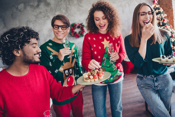 Photo of nice young people team employees eat snacks have fun enjoy cozy christmas decoration interior office indoors corporate party