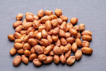 Roasted Peanuts in Wooden Bowl on Gray Background