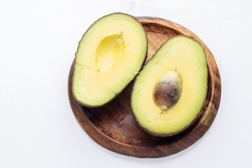 Ripe Avocado Halves on Wooden Plate