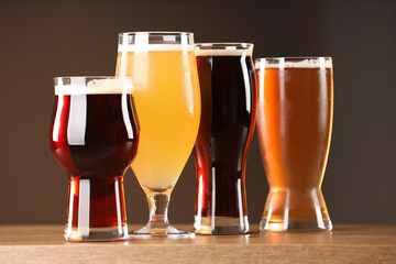 Glasses with different types of beer on wooden table indoors