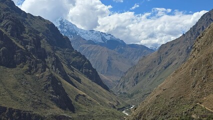 Sacred valley and snowcapped mountain in the background with clouds in the Andes Mountain range in Peru.