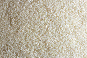 Dry Uncooked White Rice Background - Top View, Flat Lay. Scattered Raw Long Grain Rice. Asian Cuisine and Culture. Healthy Eating Ingredients. Diet Food