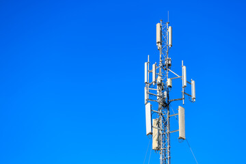 Telecommunications tower with antennas against a clear blue sky