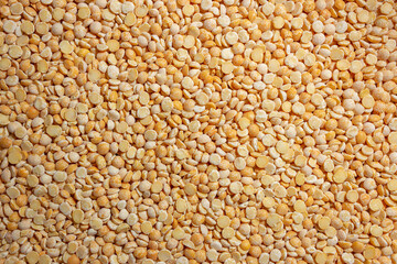 Uncooked Polished Split Peas Background. A Culinary Canvas of Dry Yellow Peas, Creating a Lively and Textured Background for Gourmet Cooking. Scattered Raw Polished Peas. Healthy Eating Ingredients