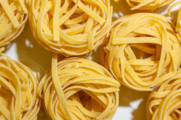 Uncooked Egg-Based Fettuccine Pasta: A Culinary Canvas of Ribbon-Shaped Macaroni, Creating a Lively...