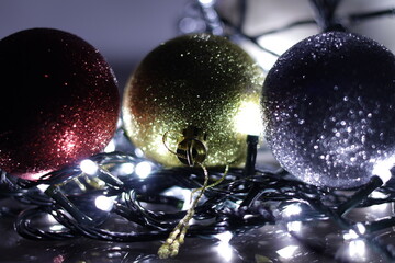 Una toma de cerca de varias bolas de navidad  de diferentes colores rodeadas de varias luces con...