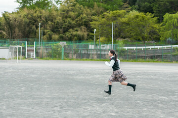 学校のグランドを走る日本人の女子中学生
