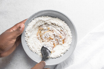 top view of mooncake dough being mixed, Overhead view of homemade mooncake dough in a grey bowl, process of making mooncakes for Lunar New Year and mid-autumn festival