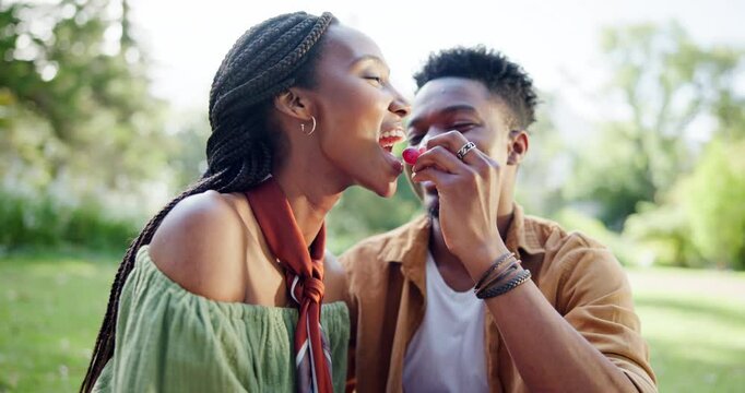 Park, couple and feeding grapes on picnic with fruit on date for fun, support and bonding in Kenya. Black people, relationship and happy or laughing at garden for care, love and hug on valentines day
