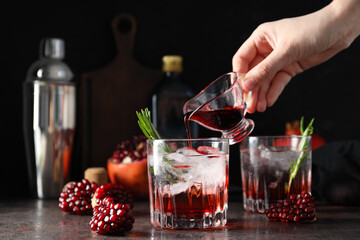 Red cocktail with fresh pomegranate on a dark background