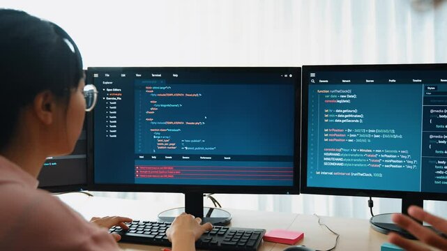 Slow motion back end software developer engineer for computer programming working together on debugging writing computing code, solving complex algorithms display on monitor in office. Burgeoning