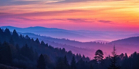 A Misty Sunrise Over a Mountain Range with Silhouetted Trees in the Foreground