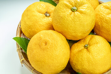Yuzu Orange fruit in wooden basket.
