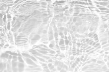 Obraz premium White water with ripples on the surface. Defocus blurred transparent white colored clear calm water surface texture with splashes and bubbles. Water waves with shining pattern texture background.