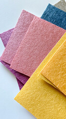 Fototapeta premium colorful textured paper sheets layered in a stack on a white background.