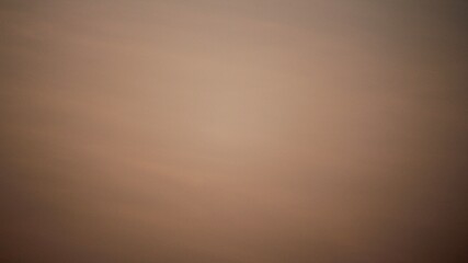 A smooth brown sky with a gentle gradient, offering a tranquil and minimalist background perfect...