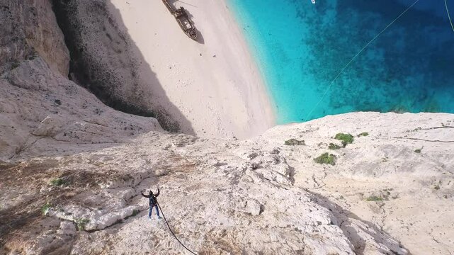 Bungee jumper leaping off Greece cliff - majestic drone shot