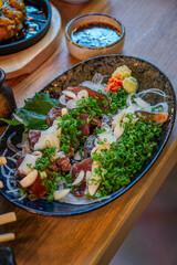 Grilled straw bonito, a signature dish from Kochi Prefecture, served sliced ​​with green onions, ginger, garlic and a special Ainanjo sauce.