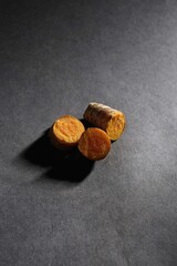 fresh turmeric root and slices isolated on dark background, turmeric (Curcuma longa Linn), spice concept